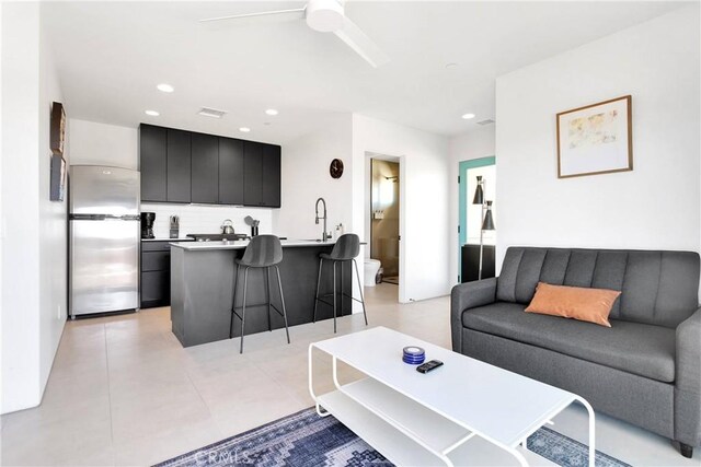 living area with a ceiling fan, recessed lighting, and visible vents