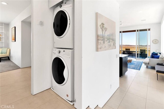 washroom with stacked washing maching and dryer, light tile patterned floors, laundry area, and recessed lighting