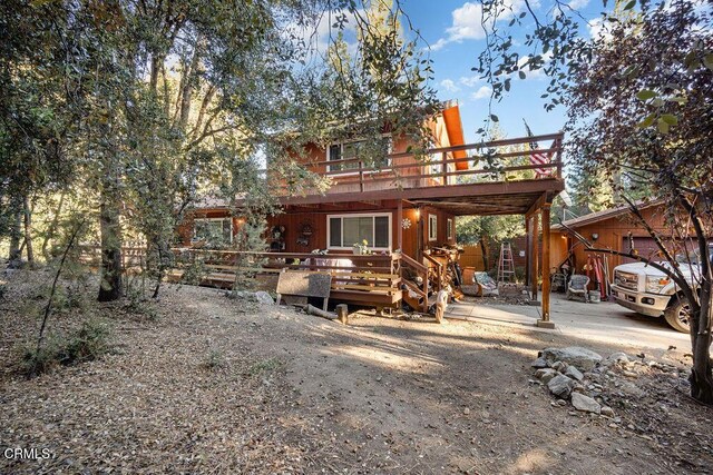 rear view of house featuring a wooden deck