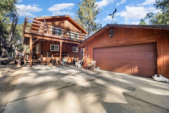 view of front of property featuring a wooden deck, an outdoor structure, and a garage