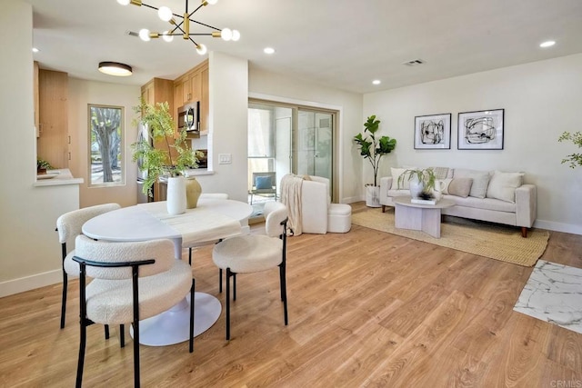dining space with an inviting chandelier, light wood-style floors, recessed lighting, baseboards, and visible vents
