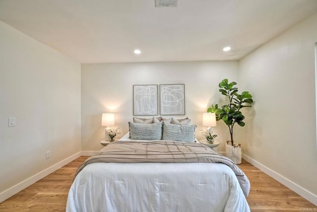 bedroom with baseboards, recessed lighting, and light wood-style flooring
