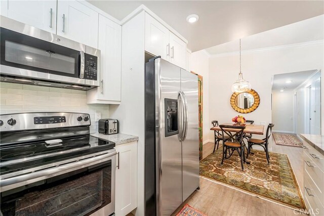 76 Calle Aragon Unit Q, Laguna Woods, CA 92637 - kitchen featuring appliances with stainless steel finishes, ornamental molding, light wood-style flooring, backsplash, and white cabinets