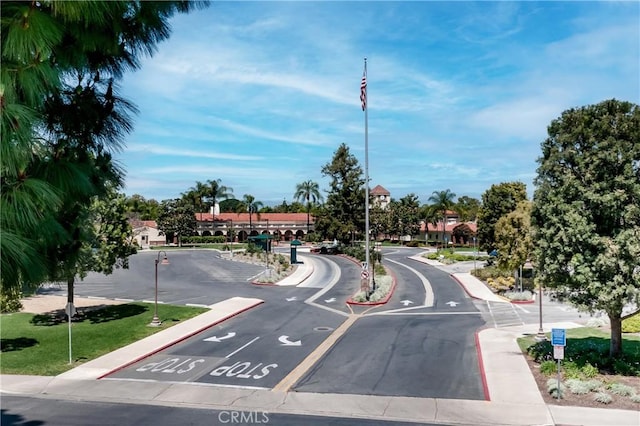 76 Calle Aragon Unit Q, Laguna Woods, CA 92637 - view of asphalt road with curbs, street lights, sidewalks, and traffic signs