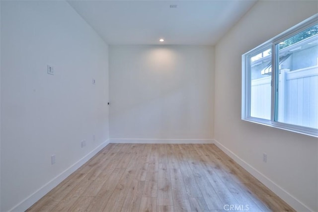 unfurnished room with baseboards, recessed lighting, and light wood-style flooring