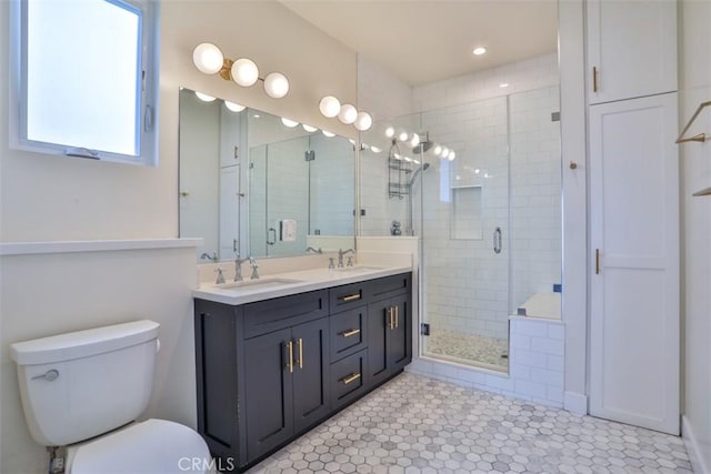 full bath with double vanity, toilet, a sink, and a stall shower