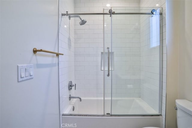 full bath featuring combined bath / shower with glass door and toilet