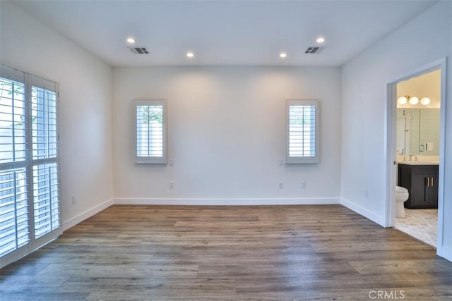 unfurnished bedroom featuring visible vents, recessed lighting, baseboards, and wood finished floors