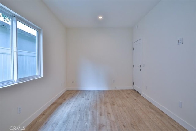 spare room with recessed lighting, baseboards, and light wood-style floors