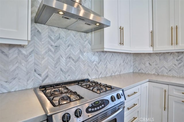 kitchen featuring stainless steel range with gas stovetop, light countertops, white cabinetry, and exhaust hood