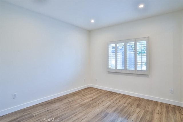 empty room featuring baseboards, recessed lighting, and wood finished floors