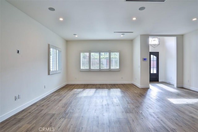 unfurnished living room featuring recessed lighting, wood finished floors, and a healthy amount of sunlight