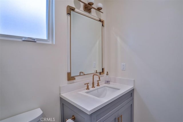 half bath featuring toilet and vanity