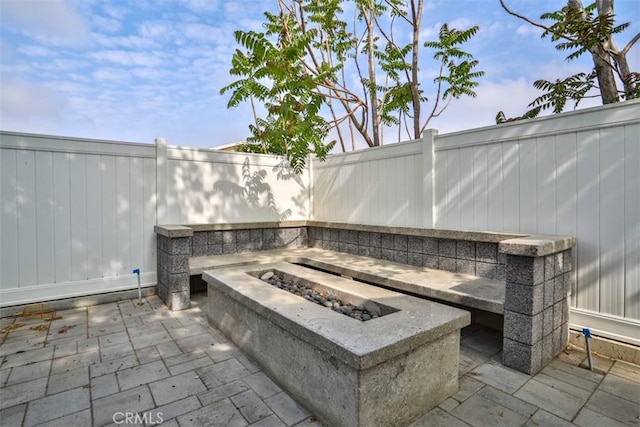 view of patio featuring an outdoor fire pit and fence
