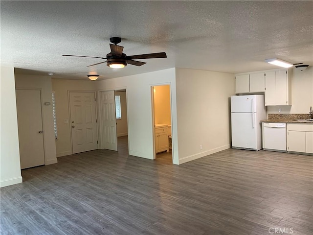 unfurnished living room featuring a sink, a ceiling fan, dark wood finished floors, and a textured ceiling