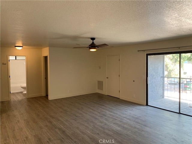 unfurnished living room with wood finished floors, a textured ceiling, and visible vents