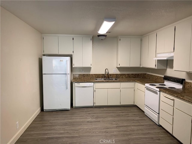 kitchen with dark wood finished floors, a sink, under cabinet range hood, white appliances, and white cabinetry