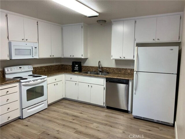 1340 W 4th St, Chico, CA 95928 - kitchen with dark countertops, a sink, white appliances, white cabinetry, and light wood-type flooring