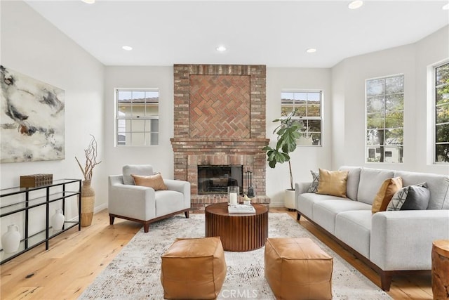 living room with recessed lighting, baseboards, wood finished floors, and a fireplace
