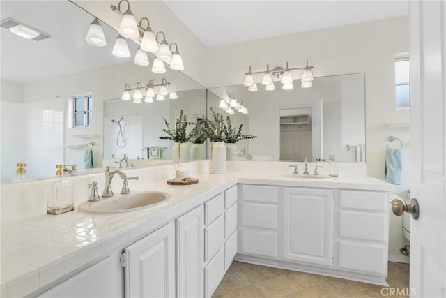 full bath featuring double vanity, plenty of natural light, and a sink