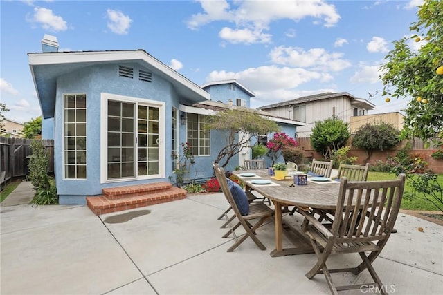 view of patio / terrace featuring a fenced backyard, entry steps, and outdoor dining space