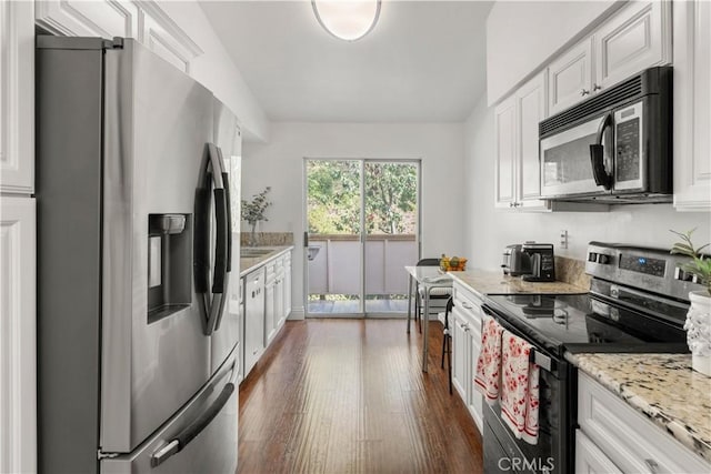 kitchen featuring white cabinets, dark wood-style flooring, appliances with stainless steel finishes, and light stone counters