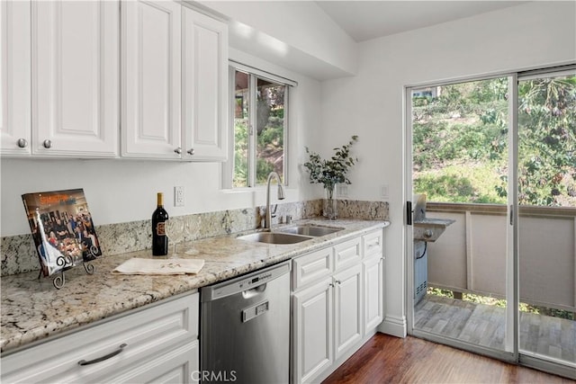 kitchen featuring plenty of natural light, a sink, dishwasher, and white cabinets