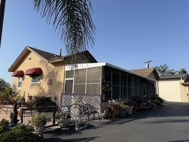view of front facade with a garage, fence, stucco siding, and driveway