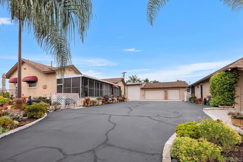 1704 Winterwarm Dr, Fallbrook, CA 92028 - view of front of house featuring a sunroom, a detached garage, and stucco siding