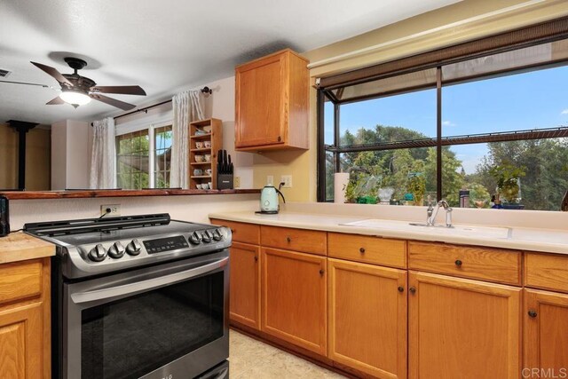 1704 Winterwarm Dr, Fallbrook, CA 92028 - kitchen with stainless steel range oven, light countertops, a ceiling fan, light tile patterned floors, and brown cabinetry