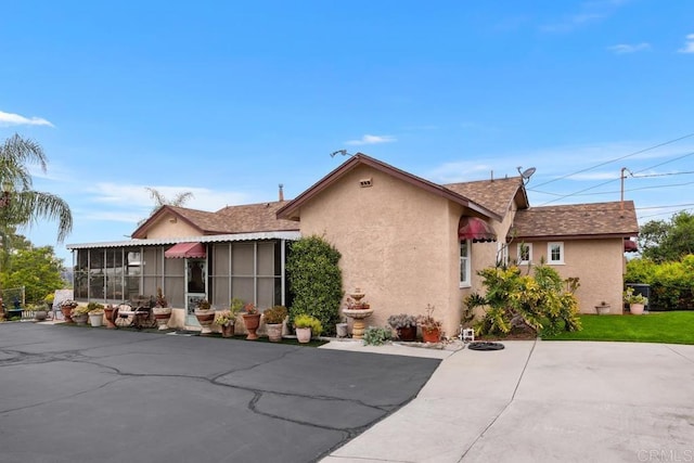 1704 Winterwarm Dr, Fallbrook, CA 92028 - view of front of house featuring stucco siding, a patio area, a sunroom, and a shingled roof