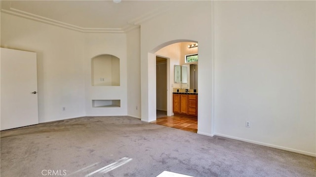 9630 El Mirador Blvd, Desert Hot Springs, CA 92240 - empty room featuring crown molding, carpet floors, baseboards, and arched walkways