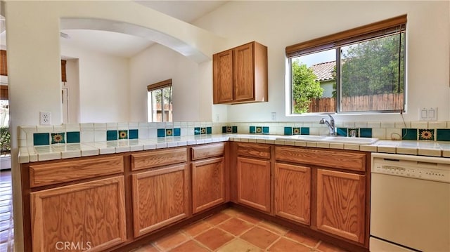 9630 El Mirador Blvd, Desert Hot Springs, CA 92240 - kitchen featuring arched walkways, brown cabinetry, a sink, and dishwasher