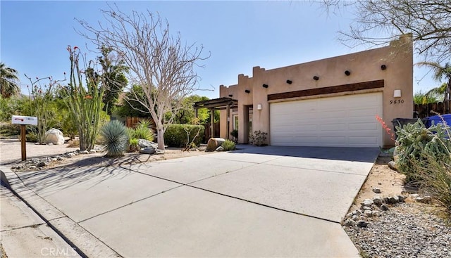 9630 El Mirador Blvd, Desert Hot Springs, CA 92240 - pueblo-style home with an attached garage, stucco siding, fence, and concrete driveway
