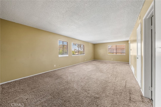 unfurnished room featuring baseboards, carpet flooring, and a textured ceiling