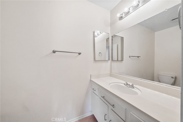 half bathroom with vanity and toilet