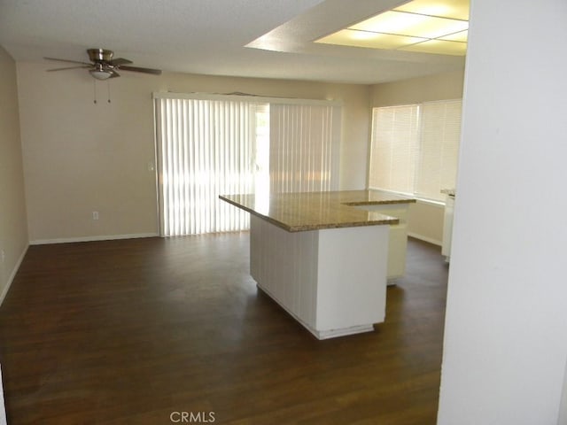 6045 Promontory Ln, Riverside, CA 92506 - kitchen featuring dark wood-style flooring, a ceiling fan, baseboards, and a center island