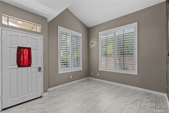 foyer with baseboards, marble finish floor, vaulted ceiling, and a wealth of natural light