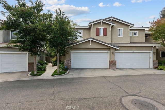 27017 Big Rpds Unit 37, Valencia, CA 91354 - view of front of property with stucco siding, an attached garage, and brick siding