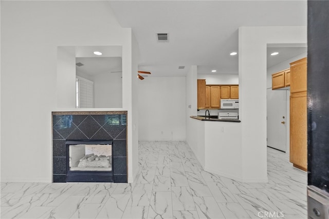 27017 Big Rpds Unit 37, Valencia, CA 91354 - kitchen featuring white microwave, light marble finish flooring, recessed lighting, ceiling fan, and a tile fireplace