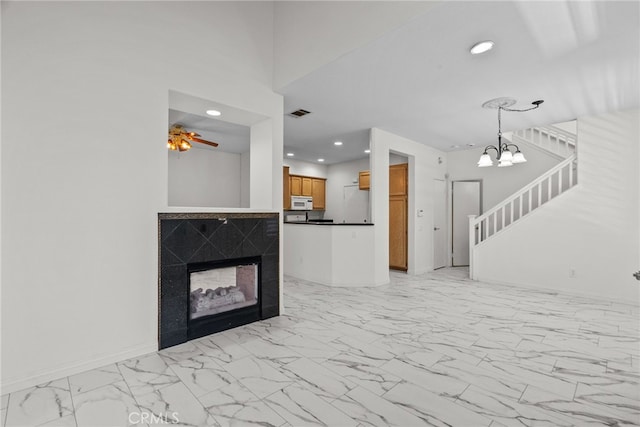 27017 Big Rpds Unit 37, Valencia, CA 91354 - unfurnished living room featuring light marble finish flooring, recessed lighting, a multi sided fireplace, a chandelier, and stairway