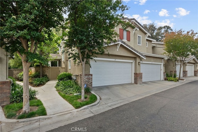 27017 Big Rpds Unit 37, Valencia, CA 91354 - view of front of home featuring stucco siding, a garage, and driveway