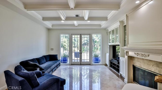 living room featuring plenty of natural light, coffered ceiling, a fireplace, and beamed ceiling