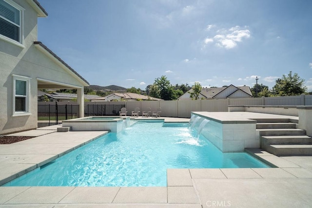 view of swimming pool with a patio, a fenced backyard, and a pool with connected hot tub