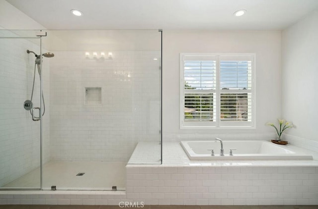 bathroom with recessed lighting, a bath, and a stall shower