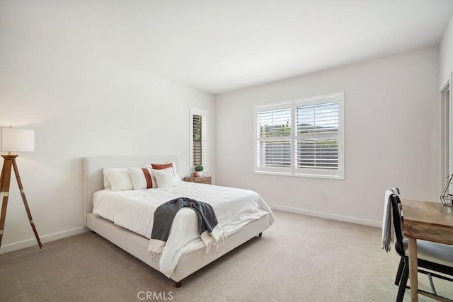 bedroom with baseboards and light carpet