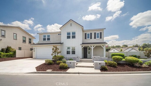 view of front of property featuring a garage, fence, stucco siding, board and batten siding, and driveway