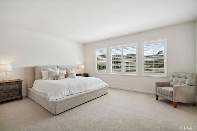 bedroom featuring baseboards and light colored carpet