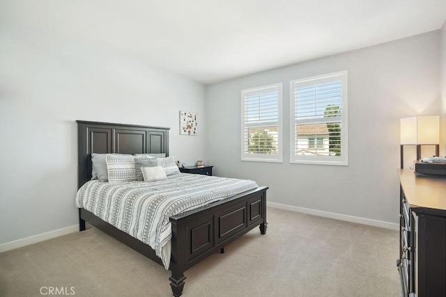 bedroom with baseboards and light carpet