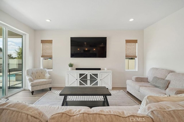 living room featuring baseboards, recessed lighting, and wood finished floors